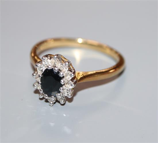 A modern 18ct gold, sapphire and diamond oval cluster ring, size S/T.